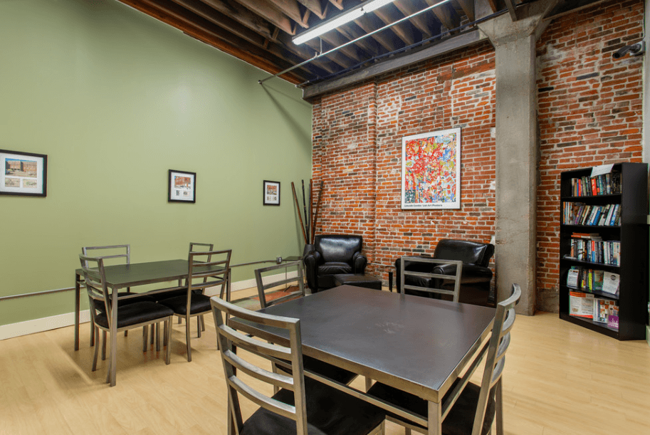 a dining room with a table and chairs and a brick wall