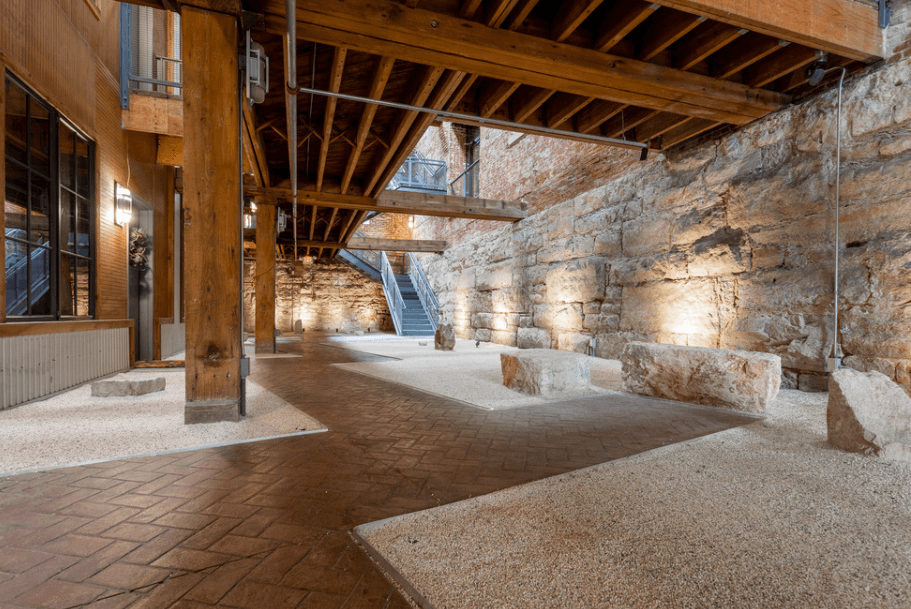 the interior of a building with stone walls and wood beams