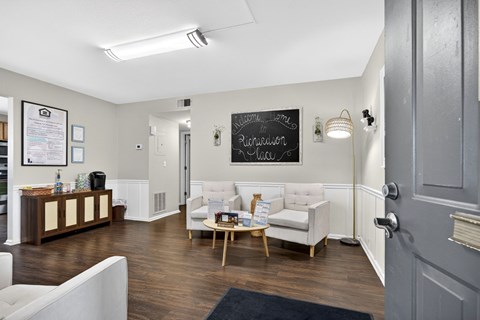 A room with a white couch and a chalkboard on the wall.
