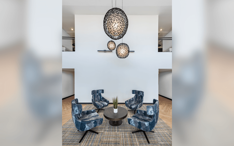 a living room with blue chairs and a round table