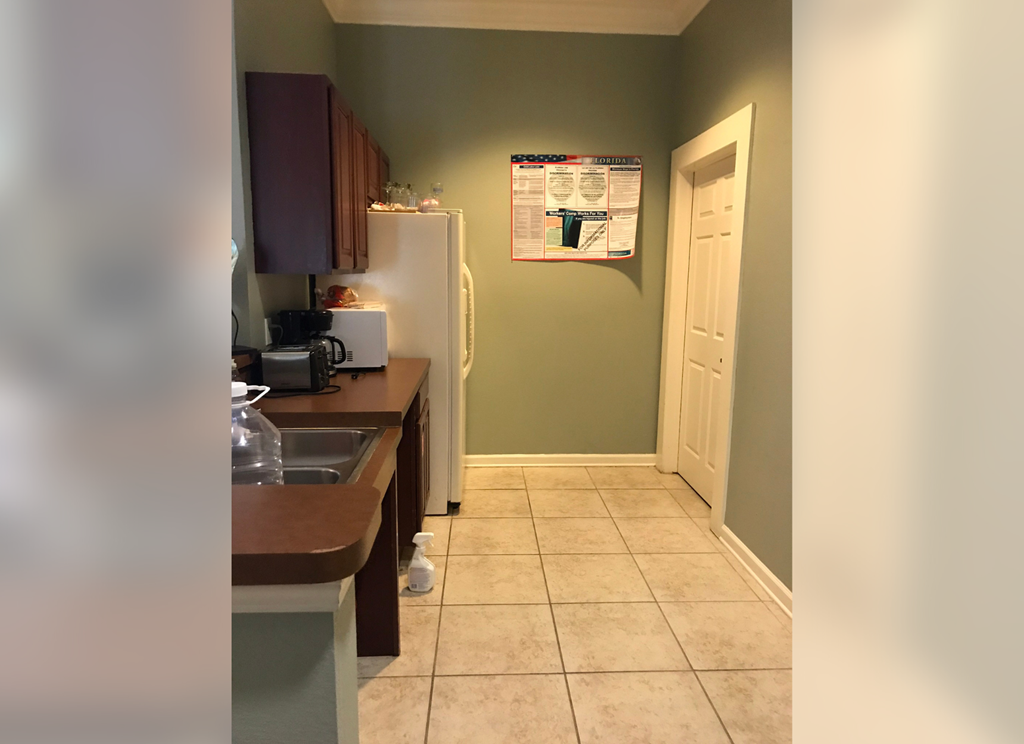 a kitchen with a sink and a refrigerator      and a door
