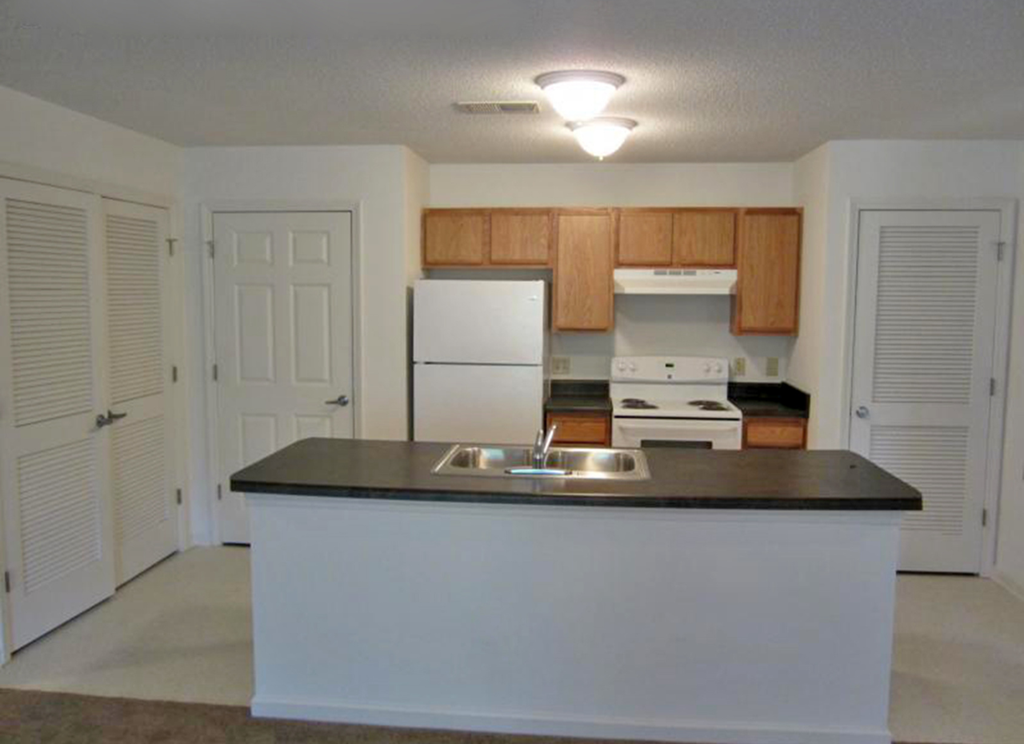 a kitchen with a counter and a refrigerator and a sink