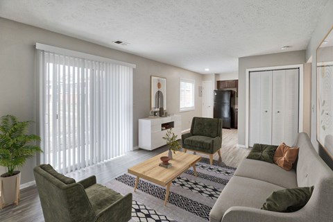 A living room with a green couch, a wooden coffee table, and a potted plant.