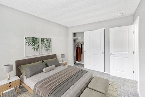 A bedroom with a bed, nightstand, and two framed pictures on the wall.