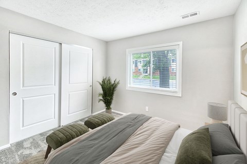 A bedroom with a large bed and a window showing an outdoor view.