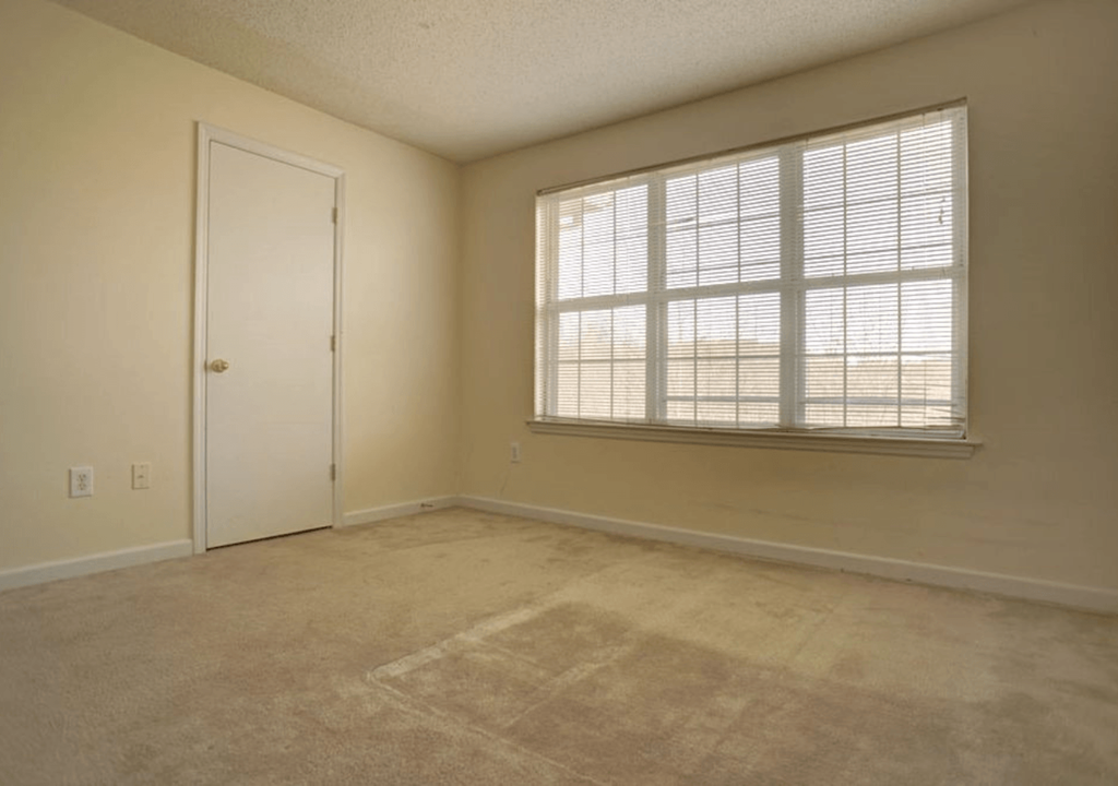 the living room of an empty house with a large window
