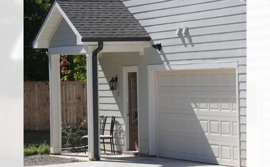 the front of a white garage with a white door