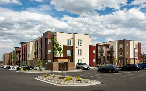a parking lot with cars in front of an apartment building