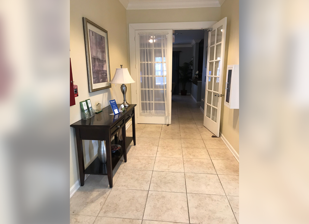 a hallway with a desk and a door into a house