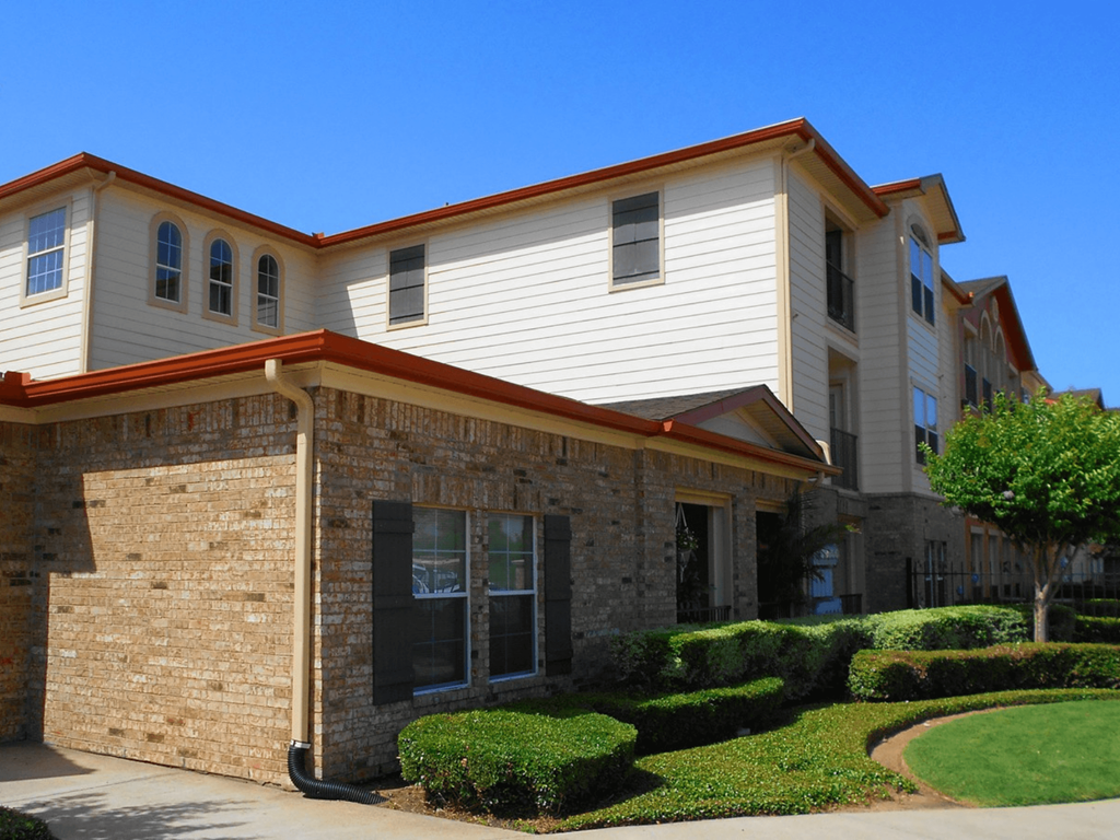 an office building with a brick and white facade and a sidewalk