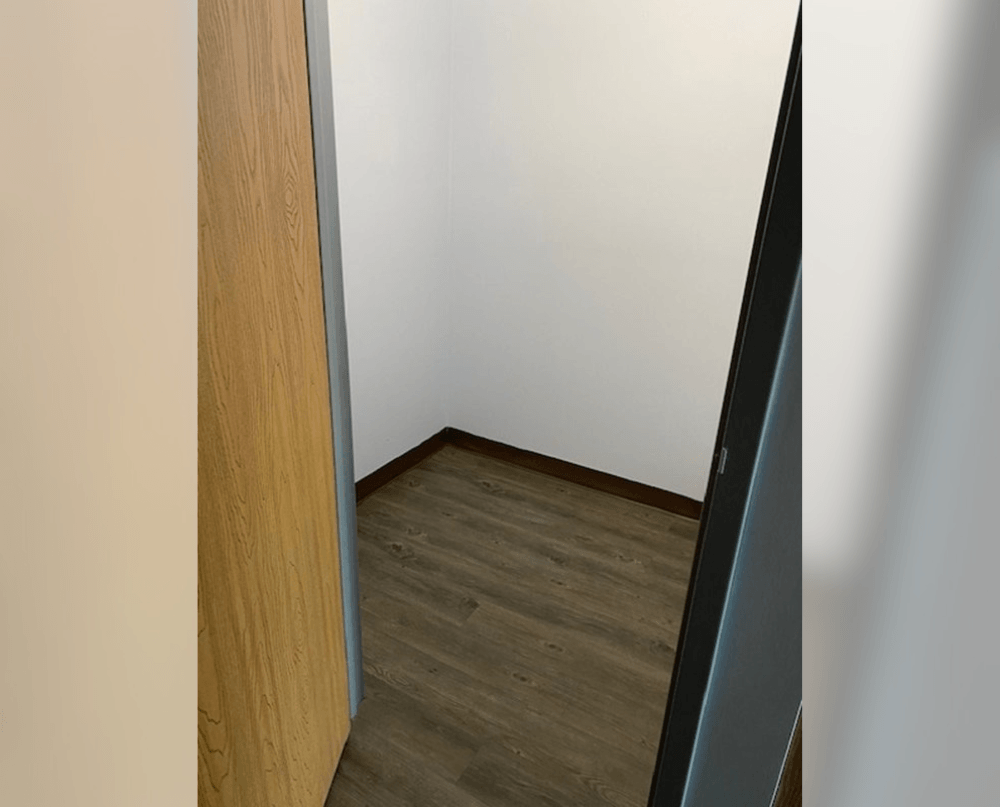 a room with wood flooring and white walls