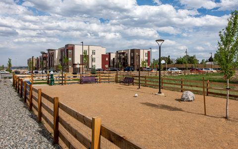 a park with a dirt playground and buildings in the background