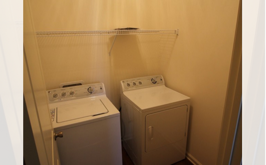 a room with a washing machine and a washer and dryer