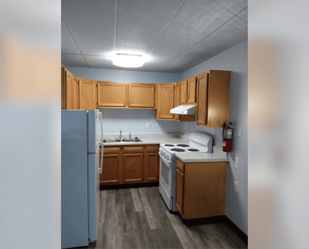 a kitchen with wooden cabinets and a white stove and refrigerator