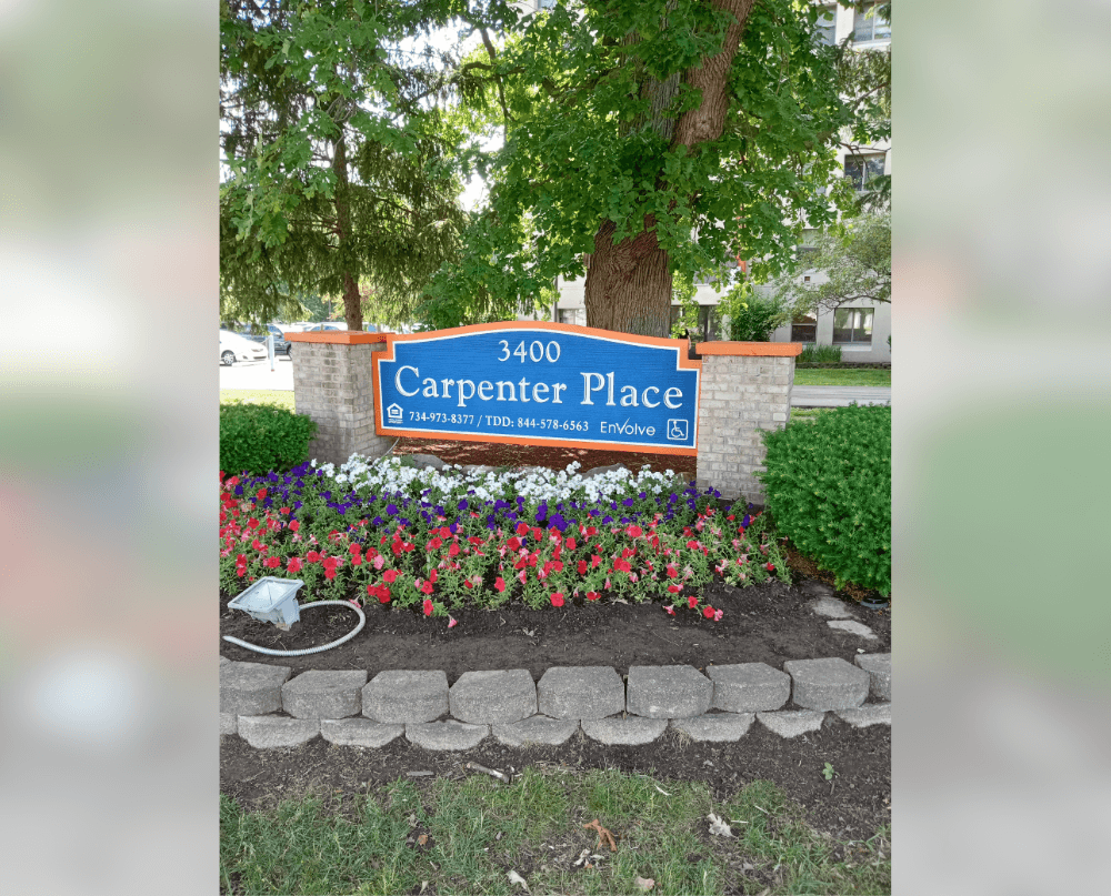 a sign for carpenter place in front of a tree