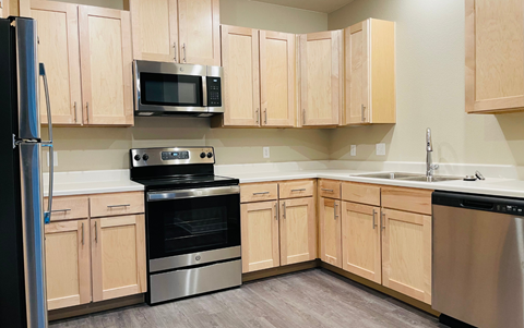 a kitchen with wooden cabinets and stainless steel appliances