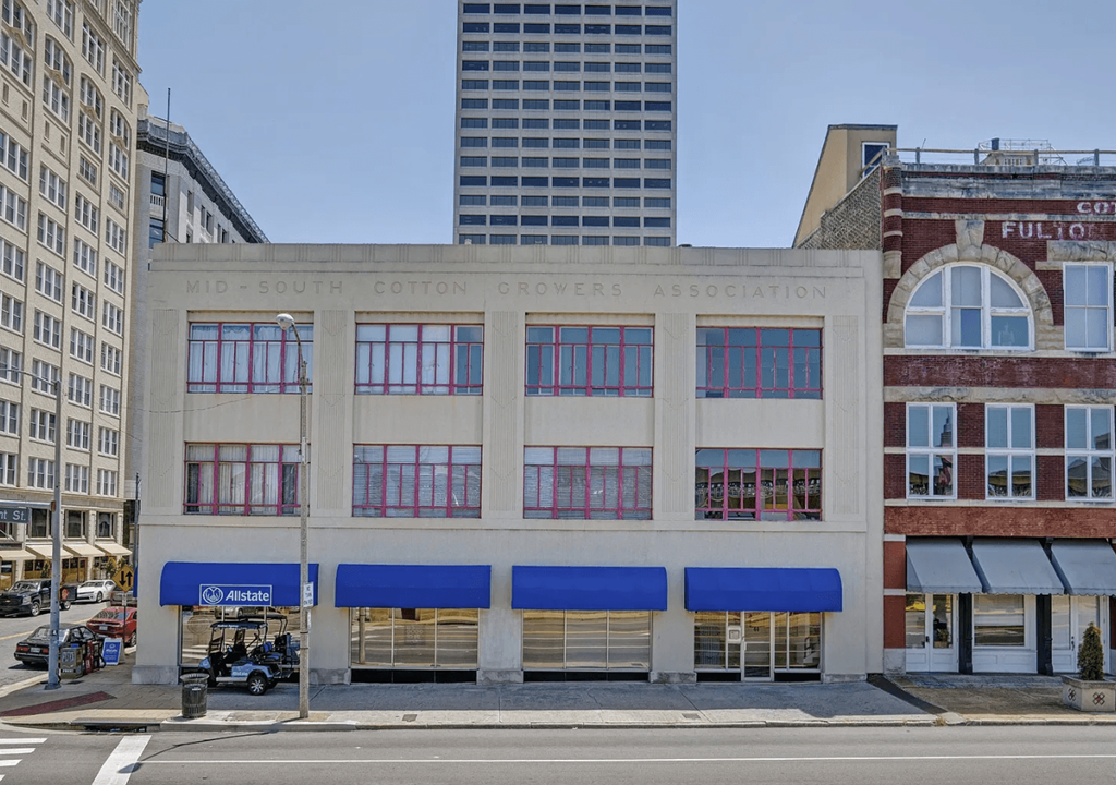 A building with a blue awning and a sign that says "Mid-South Cotton Growers Association".