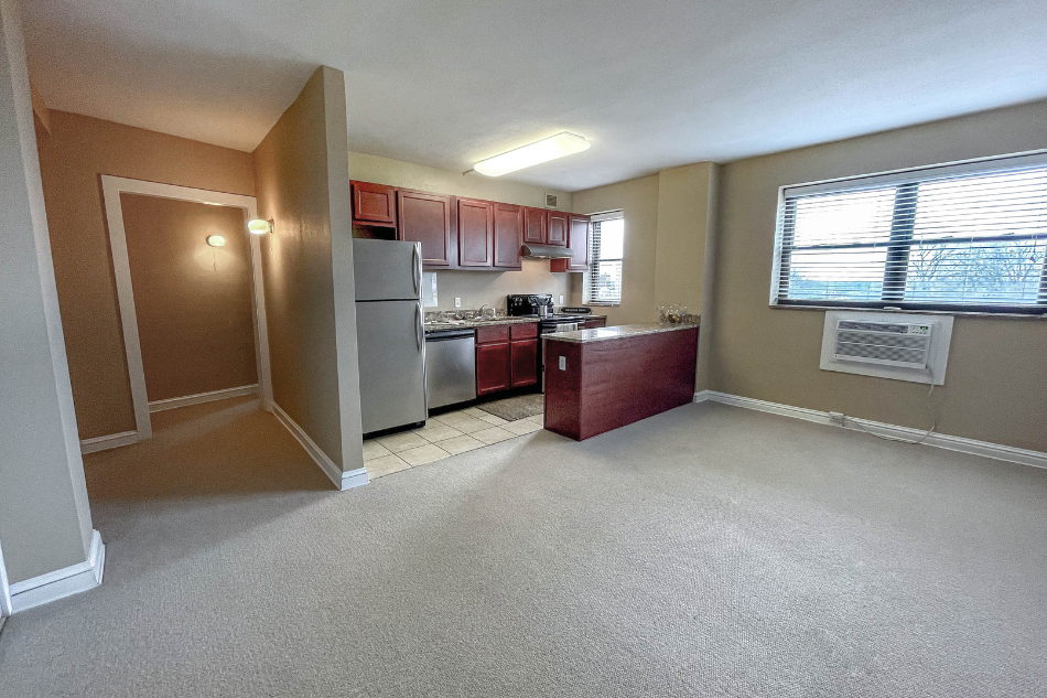 an empty kitchen with a refrigerator and a sink