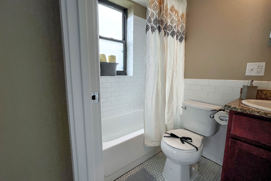 a bathroom with a toilet and a tub and a shower curtain