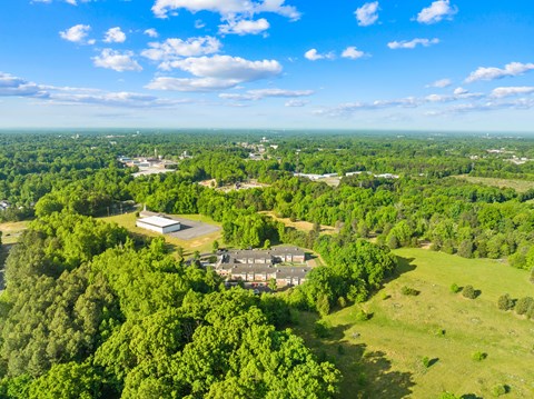A large building surrounded by trees is seen from a bird's eye view.