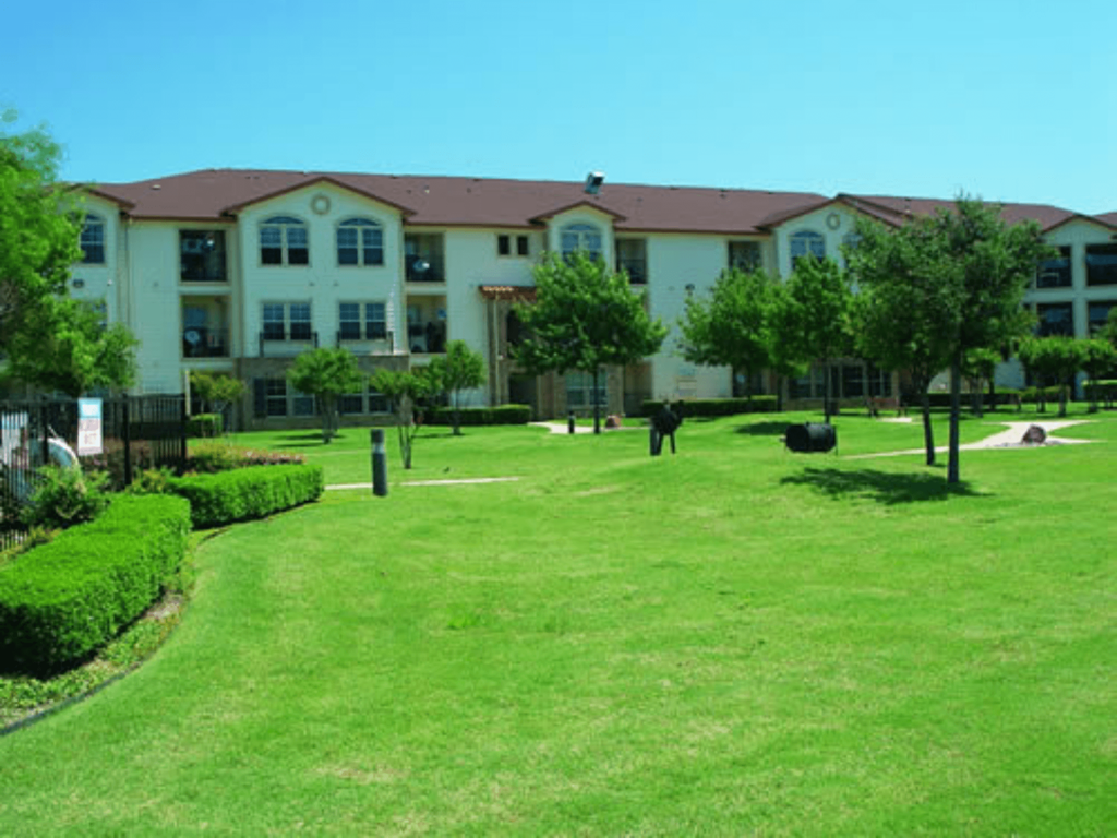 a large lawn in front of an apartment building