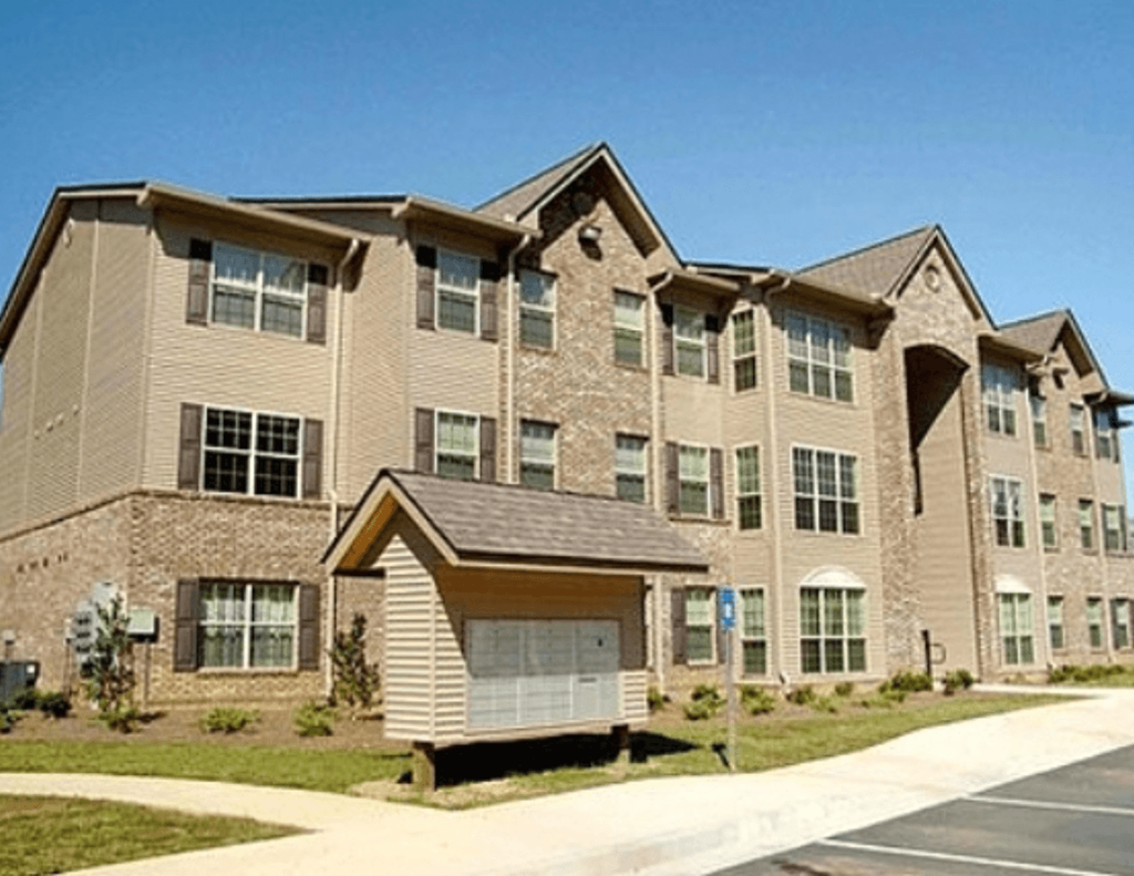 an apartment building with a sidewalk in front of it