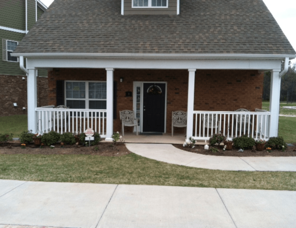 the front porch of a house with a porch swing