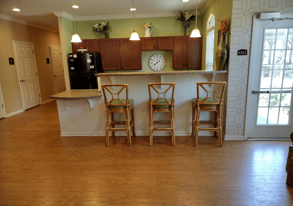 a kitchen with a counter and three bar stools