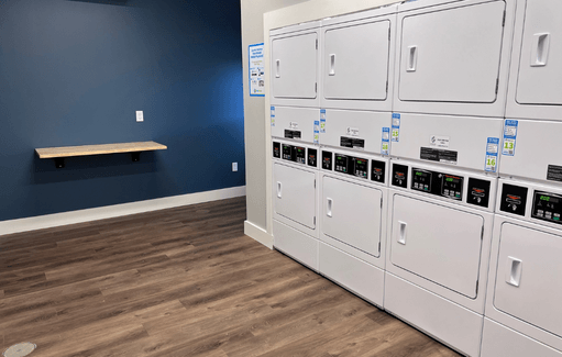 a row of white lockers in a room with wood floors