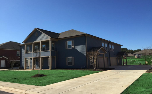 a blue house with green grass and a sidewalk