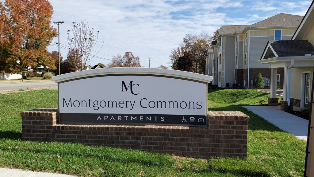 a sign in front of a house that says commons apartments