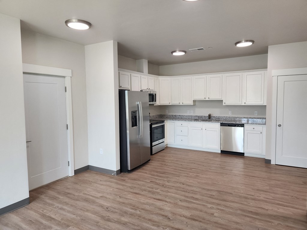 a kitchen with white cabinets and a stainless steel refrigerator