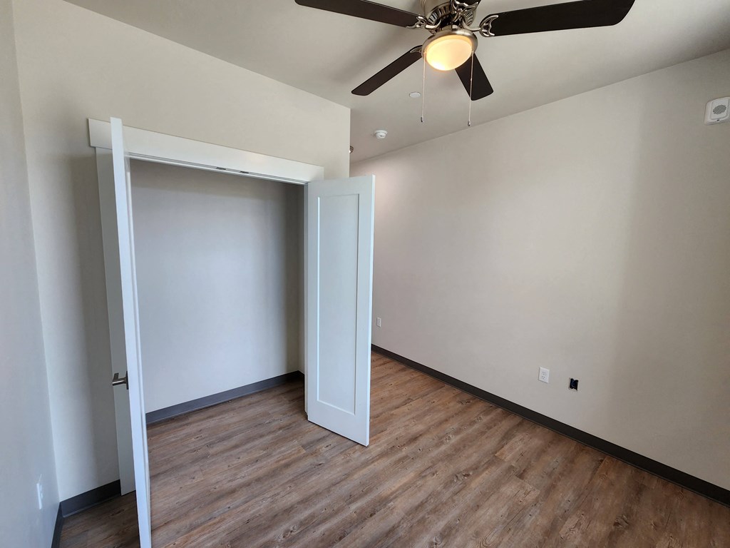 a bedroom in an empty house with a ceiling fan