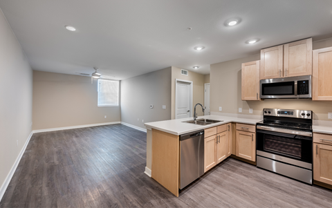 an empty kitchen with wooden cabinets and stainless steel appliances
