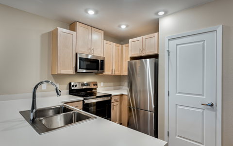 an empty kitchen with stainless steel appliances and a sink