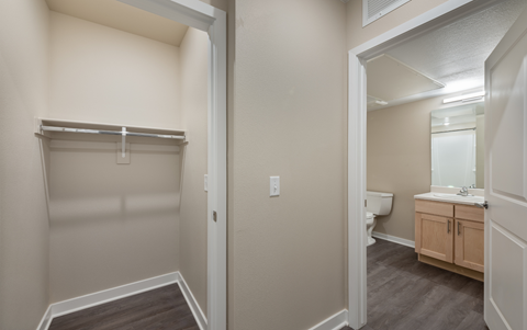 an empty bathroom with a closet and a toilet and a sink