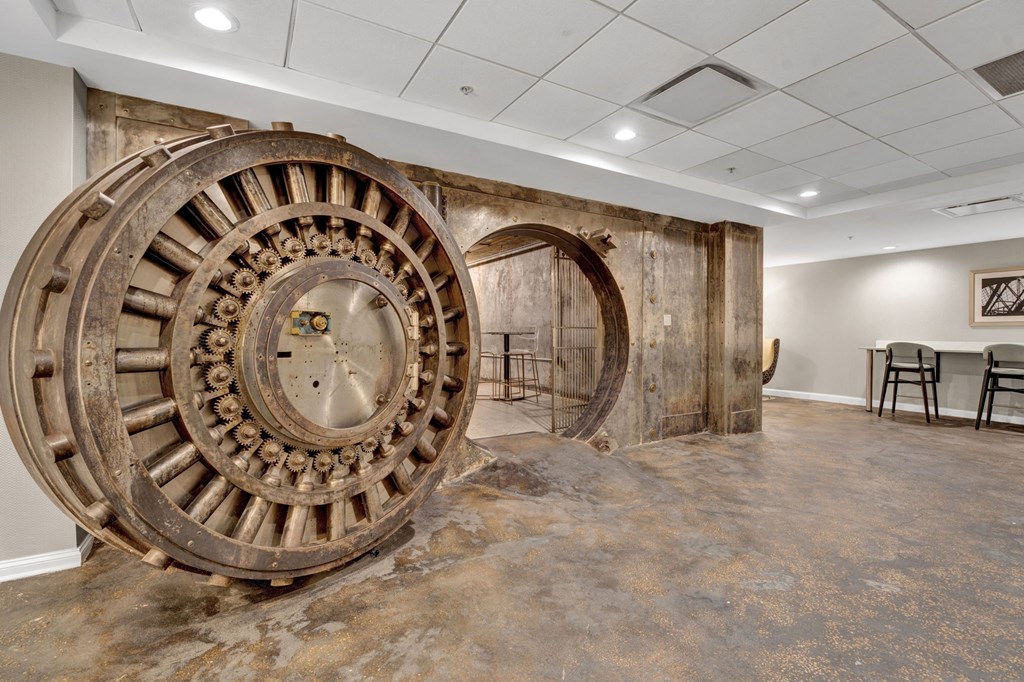 a large clock in the center of a room with a table and chairs in the background at Metro67, Memphis, 38103