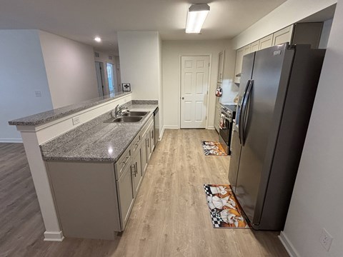 A kitchen with a granite counter top and a refrigerator.