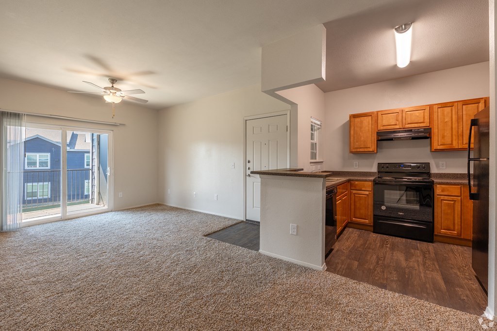 A well lit kitchen with a refrigerator, oven, and microwave.