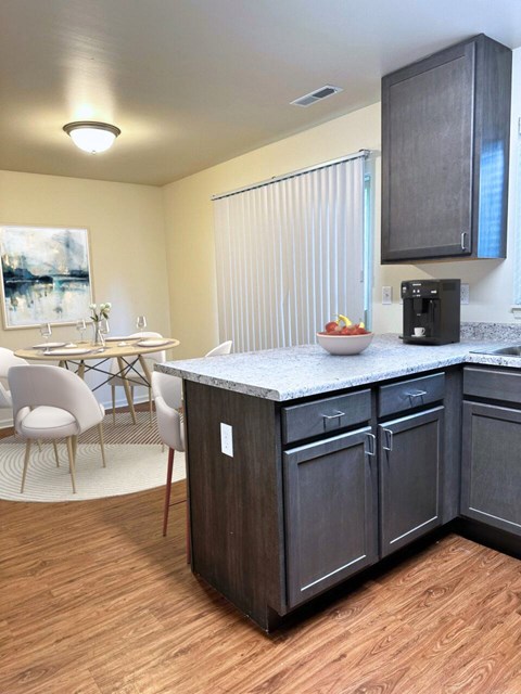 A kitchen with a table and chairs.