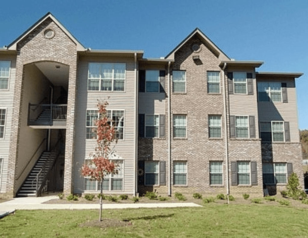 an apartment building with a tree in front of it