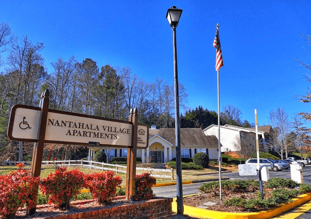 the sign for the village apartments in front of a street sign