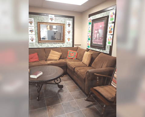 A living room with a brown couch and a round table.