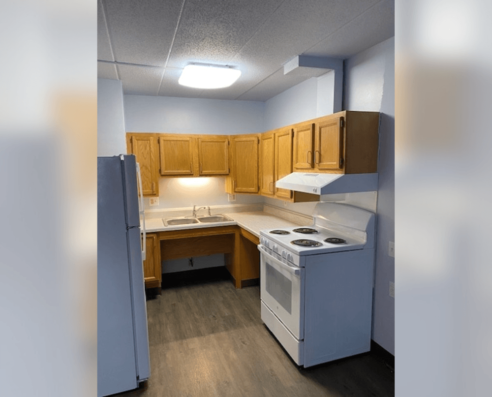 an empty kitchen with a stove refrigerator and sink