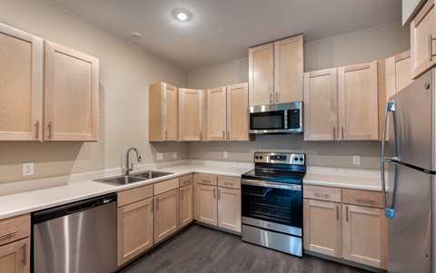 a kitchen with wooden cabinets and stainless steel appliances