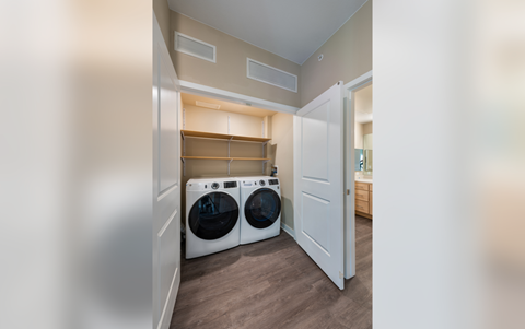 a laundry room with a washer and dryer and a closet with a door