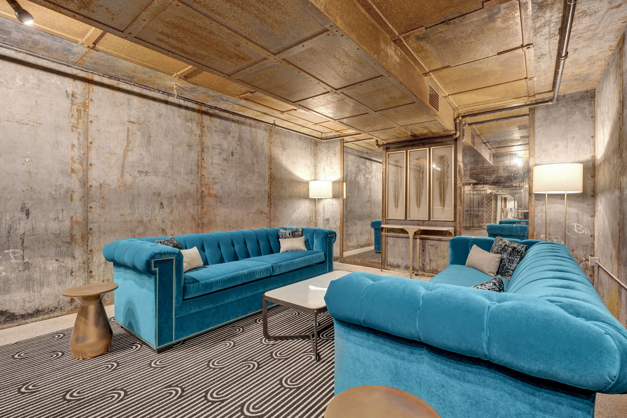 a living room with blue couches and a black and white carpet