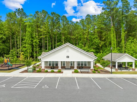 A white building with a parking lot in front of it.