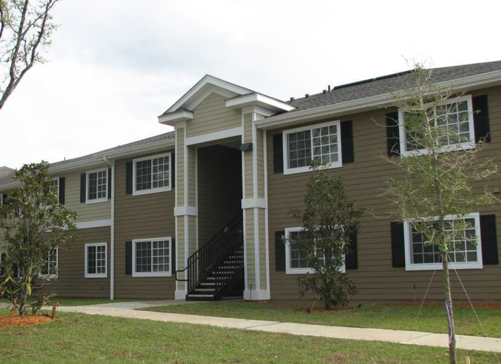 a home is shown with a sidewalk in front of it