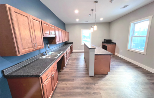 a large kitchen with wooden cabinets and a long counter top